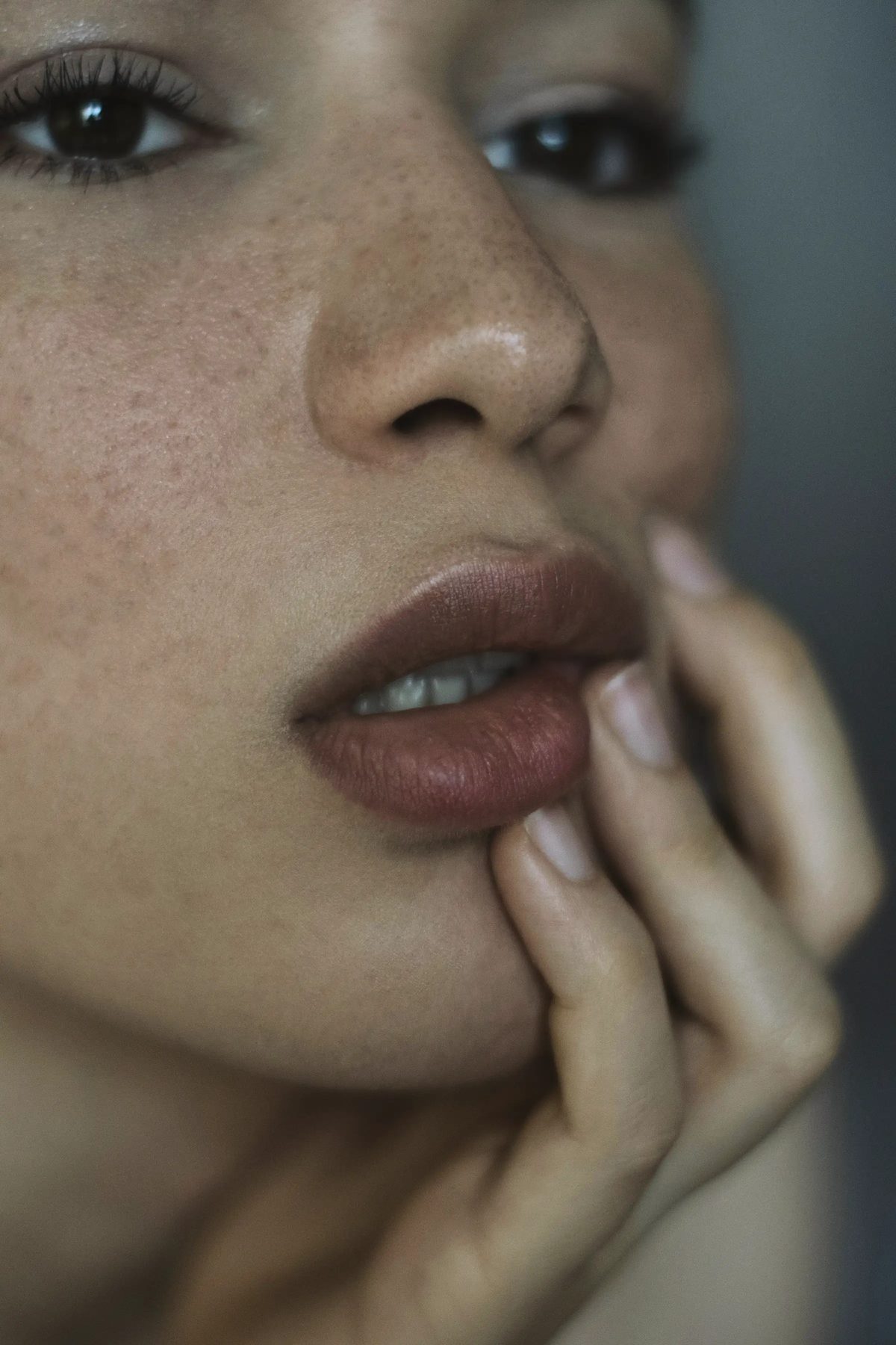 Model touching her jawline in soft natural light