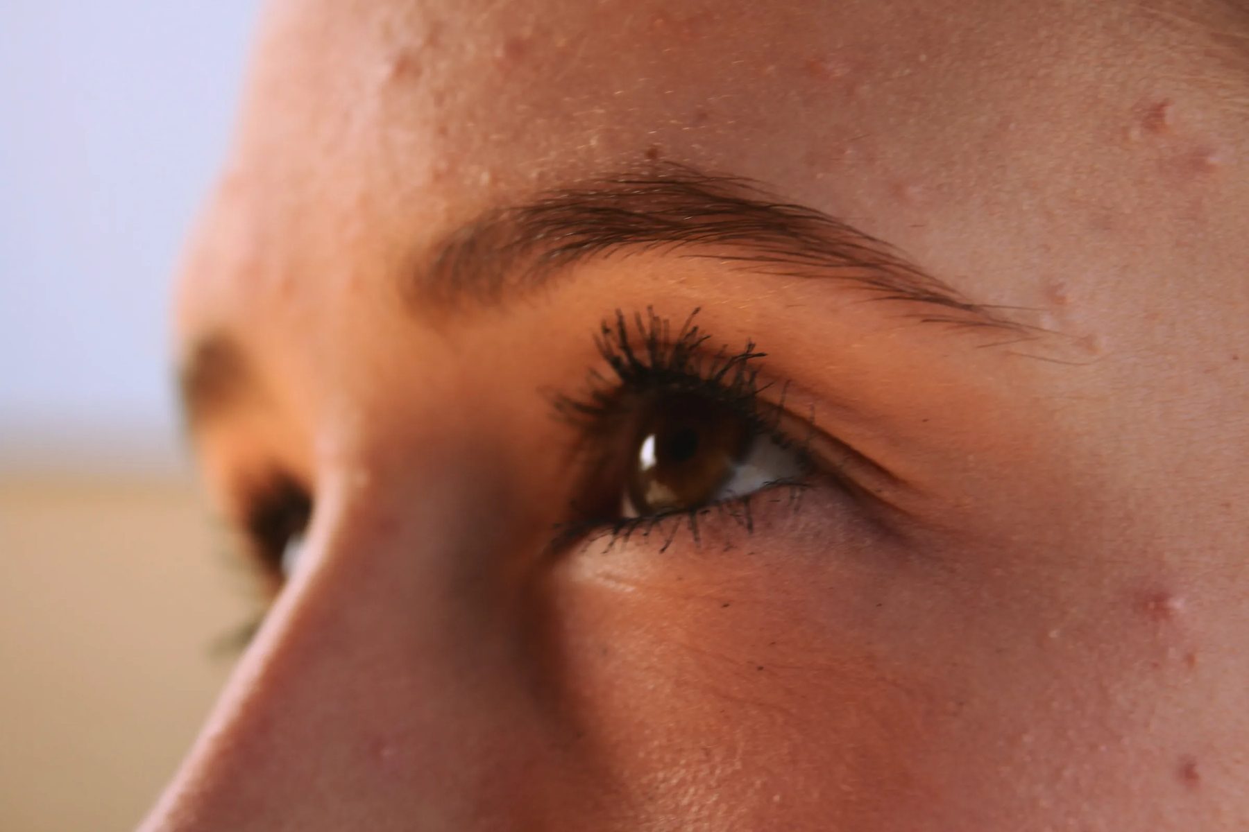 Close-up of a model’s eye and under-eye area in warm light
