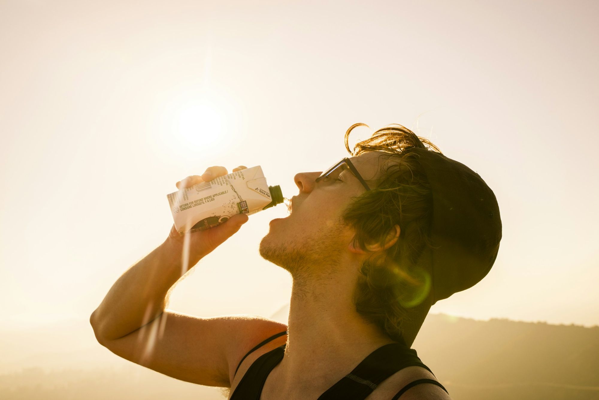 A man drinking water in bright sunlight